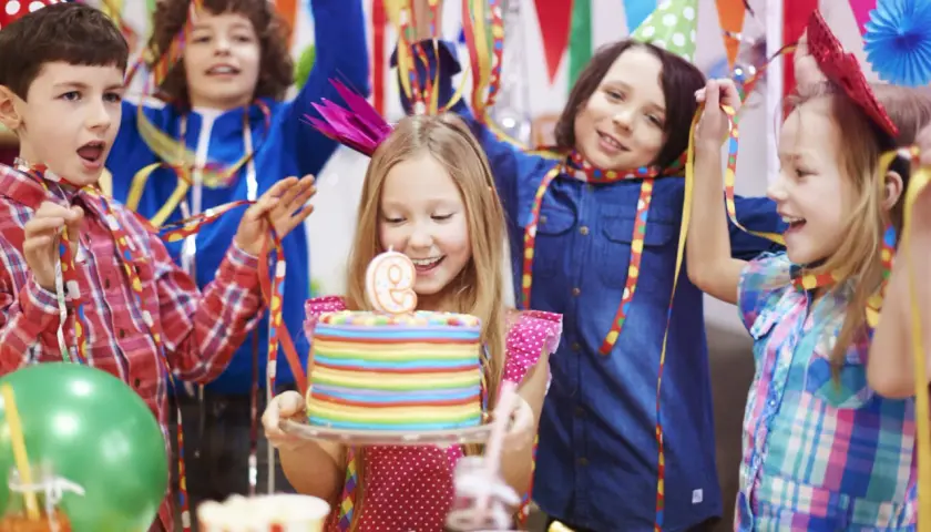 Niños celebrando un cumpleaños con pastel y globos. ¡Muchas actividades divertidas para niños!