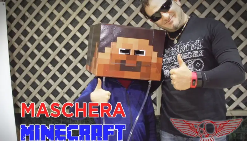 Un bambino indossa una maschera fai da te di Minecraft. Un uomo sorride e fa il pollice in su.