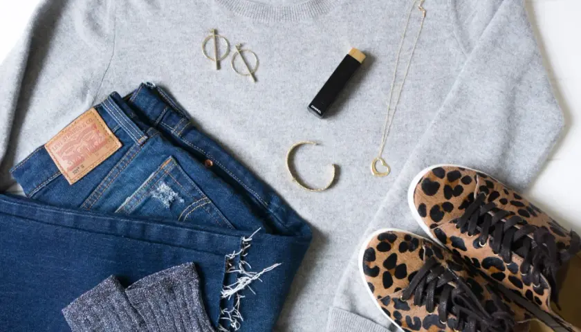 Un pull gris, un jean Levi's, des chaussettes scintillantes, des baskets léopard, un collier cœur, des boucles d'oreilles et un rouge à lèvres Chanel pour s' habiller simplement.