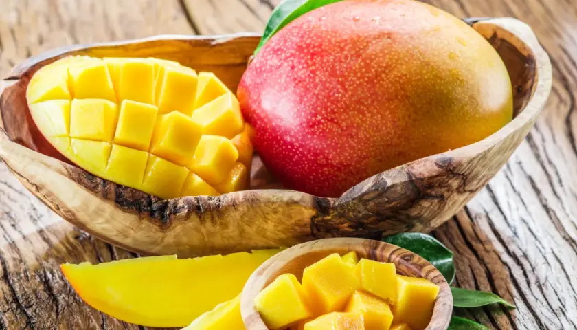Soczyste mango w drewnianej misie, pokrojone w kostkę i w plasterkach. Odkryj jego niezwykłe mango właściwości.