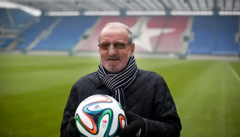 Wojciech Kwiecień, z piłką w rękach, na tle stadionu. Jego majątek to lata pracy i pasji do futbolu.