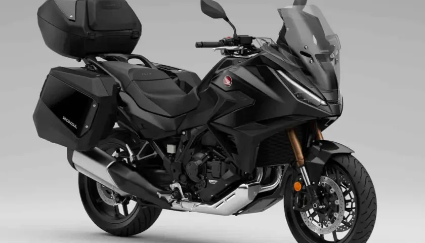 Moto automática Honda negra, lista para viajar con maletas laterales y top case.