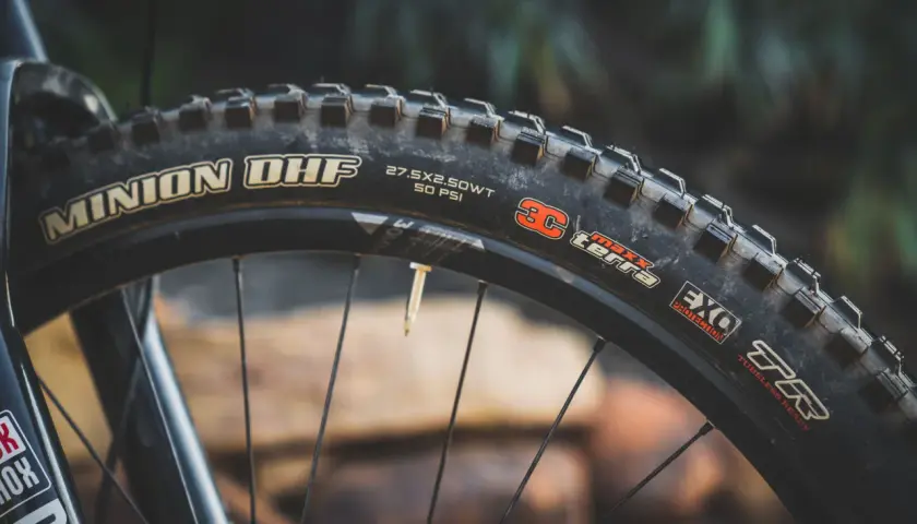 Close-up of a Maxxis Minion DHF tire, 27.5x2.50WT, 50 PSI, EXO Protection, TR. Ready for any trail, unlike the DHR.