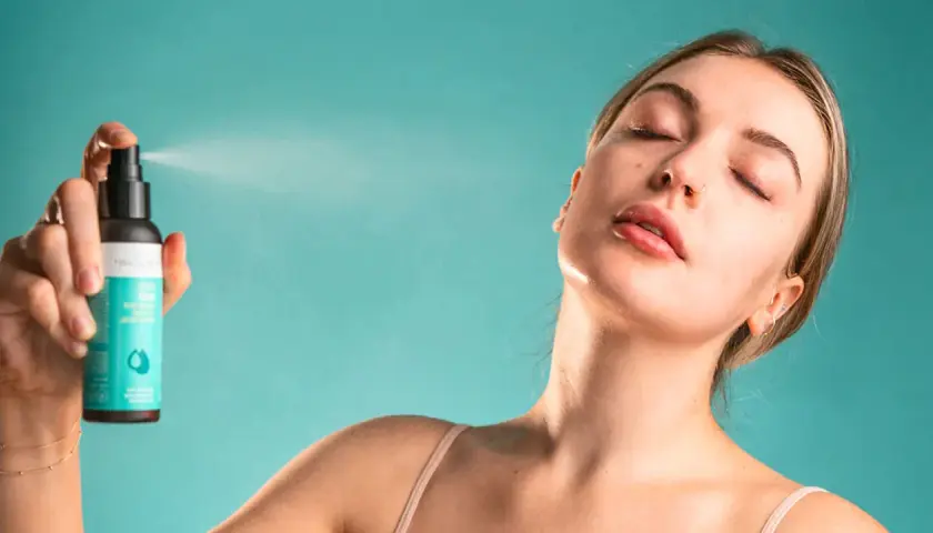 Une femme reçoit une brume rafraîchissante sur le visage. Une brume sert à hydrater et revitaliser la peau.