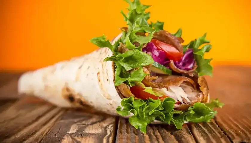 Pyszny kebab w tortilli, pełen mięsa, warzyw i sosu. Idealny na szybki posiłek, choć warto pamiętać o jego tortilla kcal.