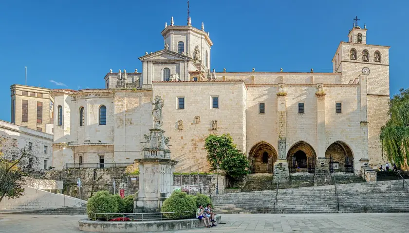 La imponente catedral de Santander se alza majestuosa bajo un cielo azul, con su fachada de piedra iluminada por el sol.