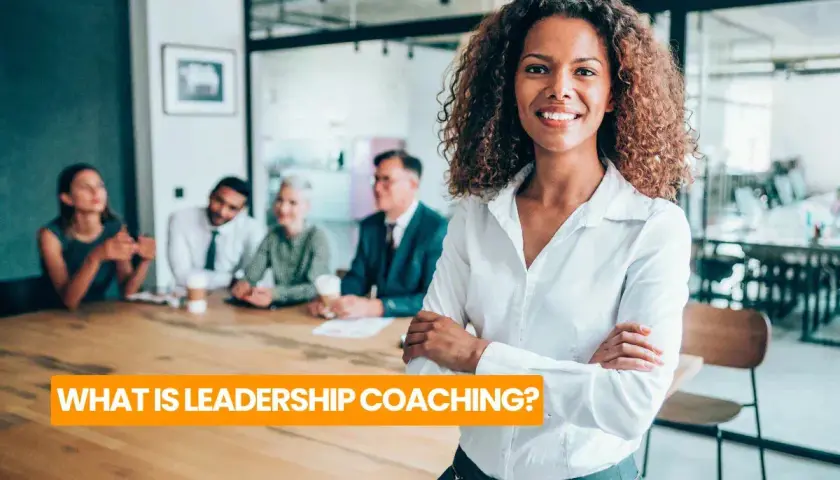 A confident woman leads a team meeting, embodying the essence of leadership coaching definition.