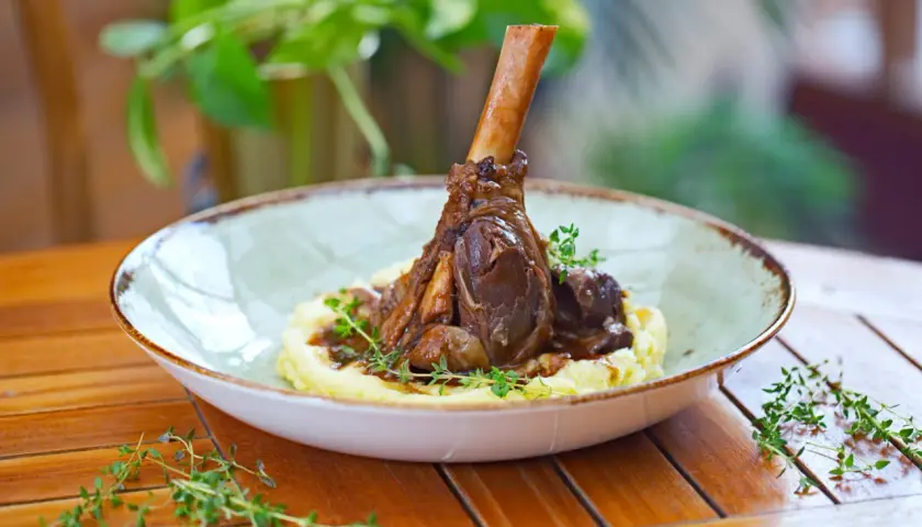 Une souris d'agneau braisée, servie sur une purée onctueuse et garnie de thym frais. Un plat savoureux et réconfortant.