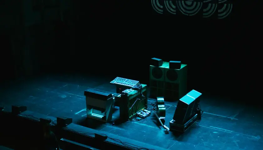 Scen för jazzfestival med synthesizers, högtalare och en fiol.