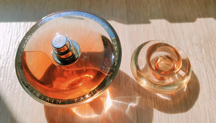 Perfumy Guerlain Insolence w szklanych flakonach, z wygrawerowaną nazwą marki i produktu.