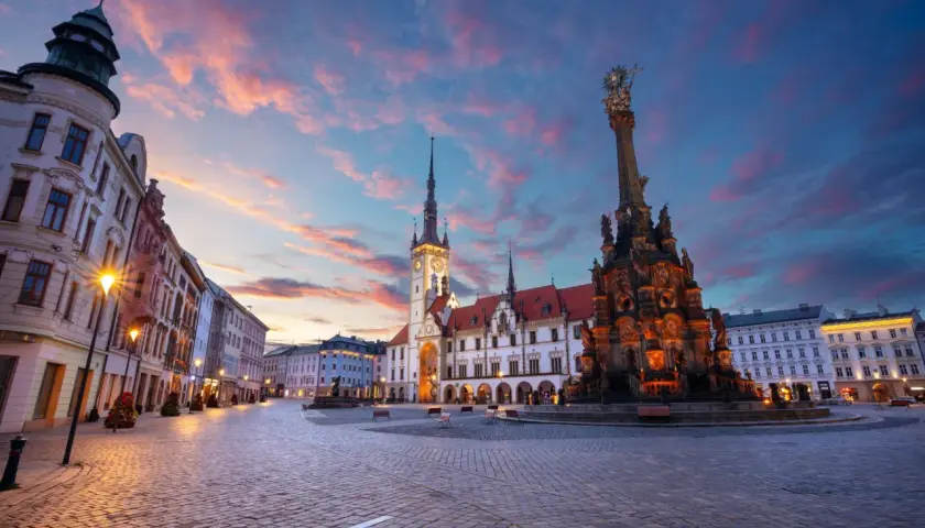 Zachód słońca nad pięknym rynkiem w Olomoucu, z widokiem na zabytkowy ratusz i Kolumnę Trójcy Świętej. Dolina Morawy wita o zmierzchu.