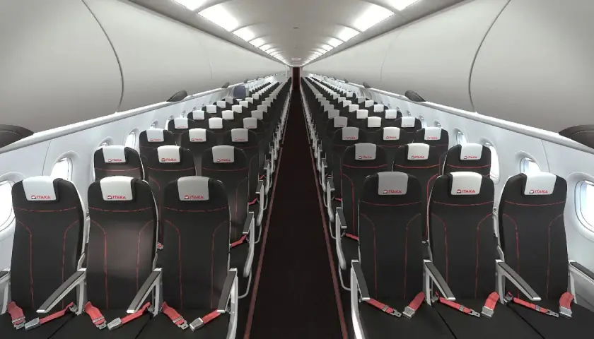 Wnętrze samolotu linii lotniczych Electra Airways. Rzędy czarnych foteli z czerwonymi przeszyciami i białymi zagłówkami z logo ITAKA.