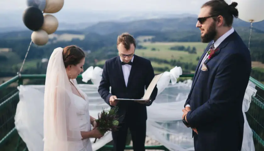 Para_młoda podczas ślubu cywilnego w górach. W tle malowniczy krajobraz, a obok balony.