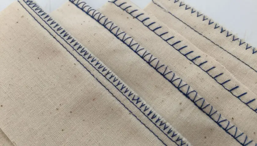 Close-up of beige fabric with neat, blue serger stitches. This is what a serger does: finishes edges beautifully.