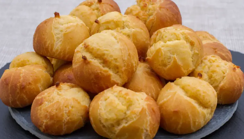 Pile de gougères dorées et gonflées, parfaites pour apprendre comment faire gonfler des gougères.