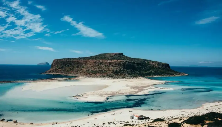 Traumhafte Lagune mit türkisfarbenem Wasser und einer imposanten Berginsel. Welche griechische Insel könnte das sein? Balos auf Kreta.
