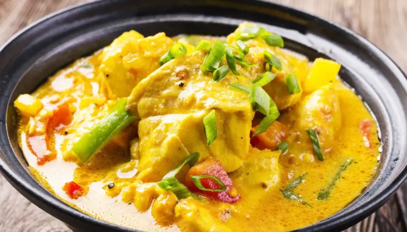 Aksamitne curry bez mięsa z kawałkami tofu, papryką i zieloną cebulką w aromatycznym, żółtym sosie.