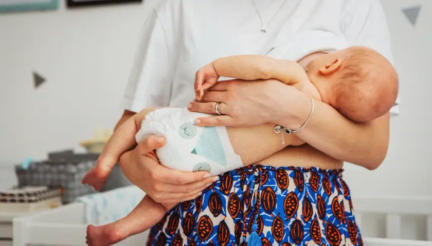 Mama tuli dziecko, które mogło się przegrzać. Widać pieluszkę i jej ramiona.