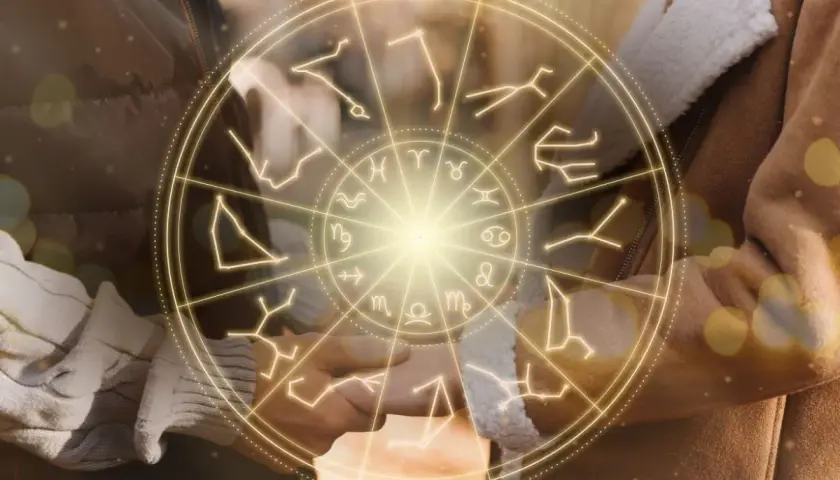 Zodiakalny krąg z symbolami gwiazd, w tym panna, otacza dłonie pary.