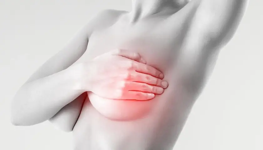 Mano che copre il seno con un'area rossa che indica bruciore e ansia.