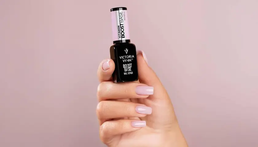 Dłoń prezentuje lakier Victoria Vynn Boost Base. Zastanawiasz się, najpierw primer czy baza? Ten produkt to idealny wybór na start.