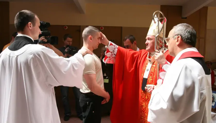 Biskup udziela sakramentu bierzmowania dorosłemu. Warto wiedzieć, ile kosztuje bierzmowanie dla dorosłych, choć cena jest symboliczna.