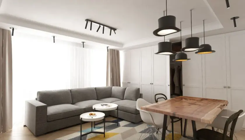 Nowoczesny salon z szarą kanapą, stolikami kawowymi i stołem z litego drewna. Inspiracja, jak umeblować salon, by był funkcjonalny i stylowy.