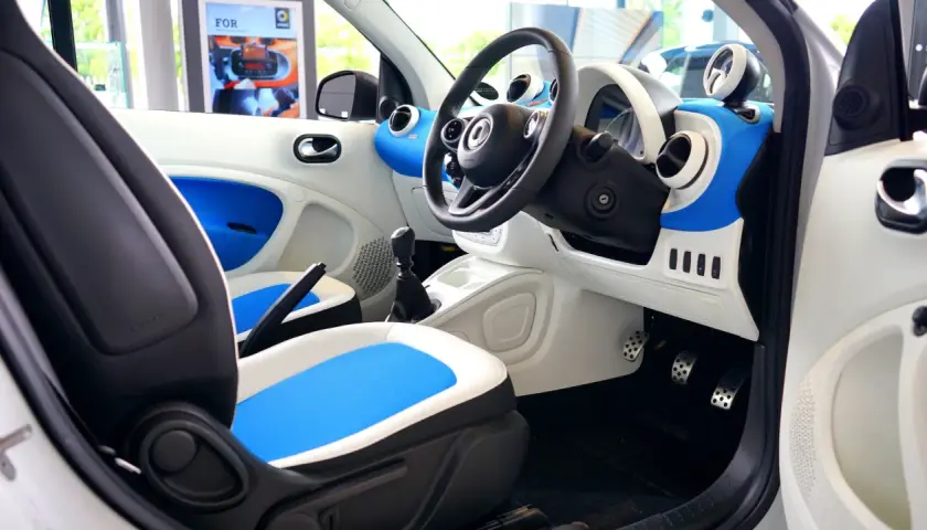 Wnętrze samochodu Smart. Widoczne pedały: po lewej hamulec, po prawej gaz.