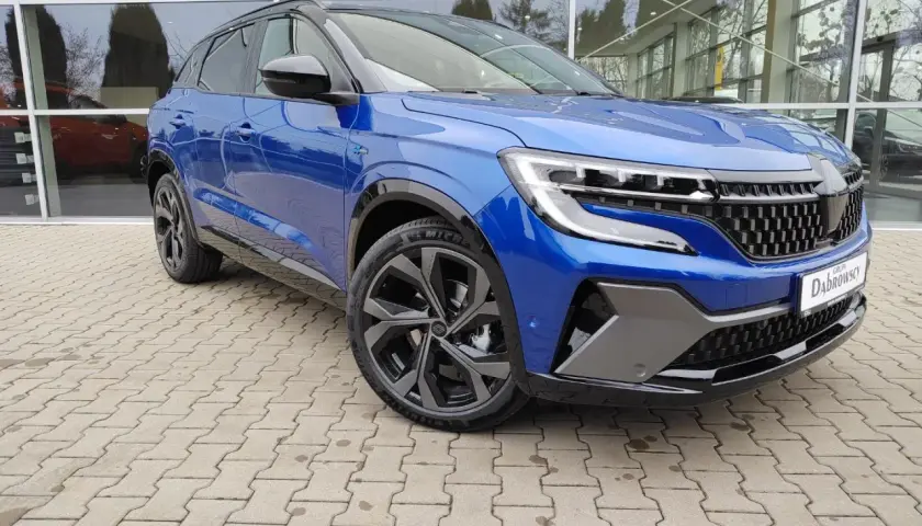 Niebieski Renault Austral prezentuje swoje imponujące wymiary na tle salonu samochodowego. Elegancki SUV z dynamiczną linią.
