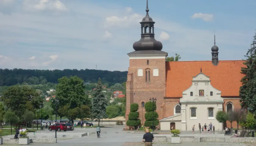 Włocławek atrakcje na weekend: plac z zabytkową katedrą, zielony park i ludzie spacerujący w słoneczny dzień.