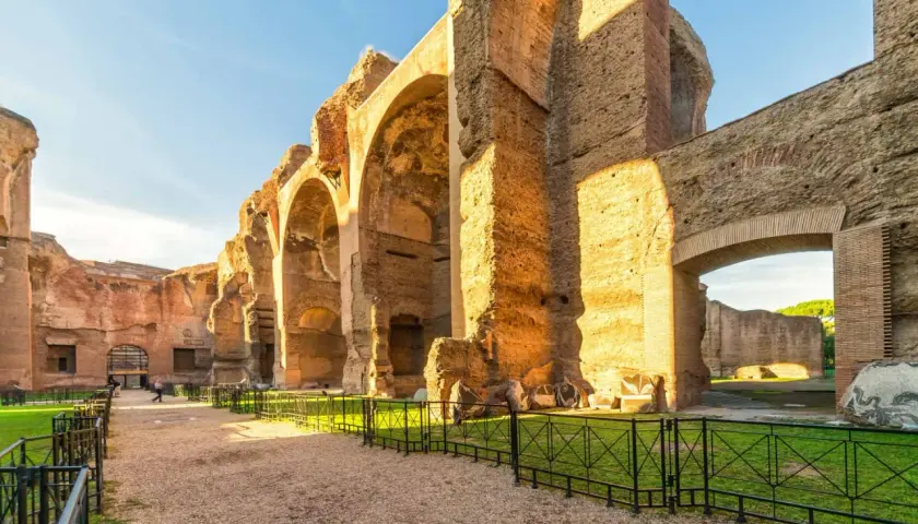 Vestiges impressionnants du **bain de Caracalla** à Rome, avec ses arches massives en briques et pierre, baignées par le soleil.