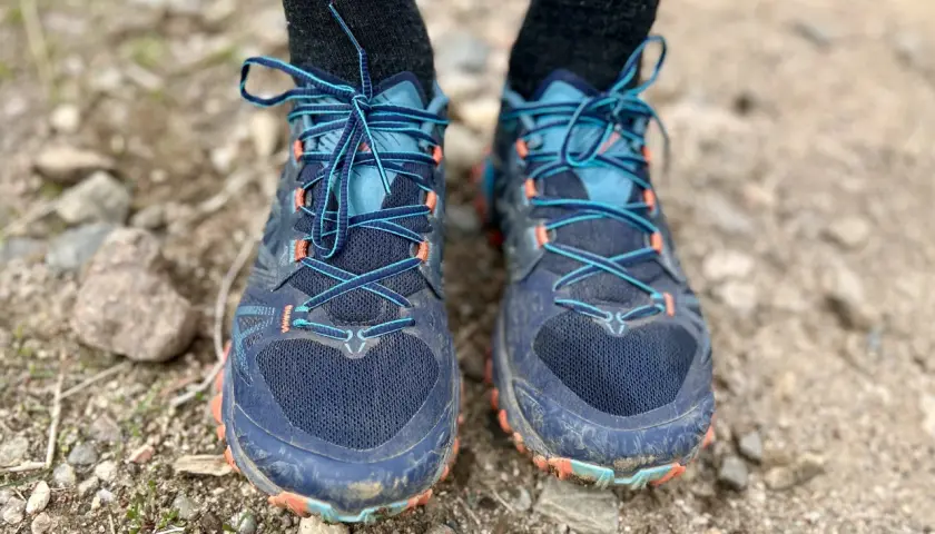 Close-up of a pair of La Sportiva Bushido III trail running shoes, laced up and ready for adventure on a rocky path.