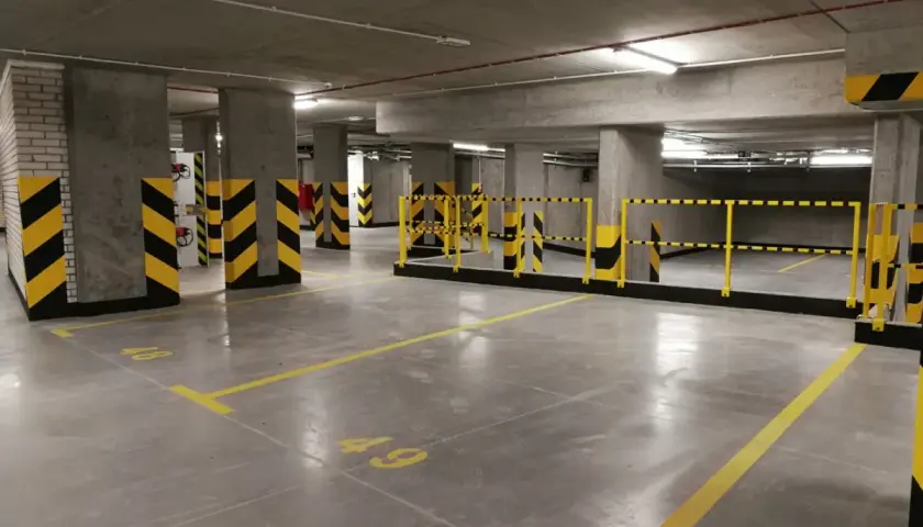 Podziemny parking z miejscami oznaczonymi numerami 48 i 49. Zastanawiasz się, ile kosztuje miejsce parkingowe w Warszawie?