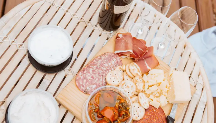 Un plateau de charcuterie, fromages et trempettes, prêt à être dégusté avec un bon vin. Quel vin avec charcuterie ? C'est la question parfaite pour ce moment convivial.