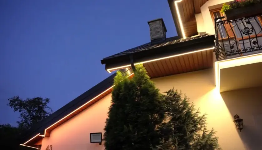 Eleganckie oświetlenie w podbitce domu, rozmieszczone co kilka metrów, tworzy ciepłą atmosferę wieczorem.