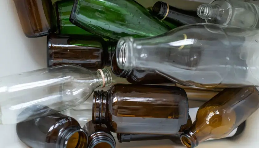 Stos szkła do recyklingu: brązowe i zielone butelki, ciekawe ciekawostki o recyklingu.