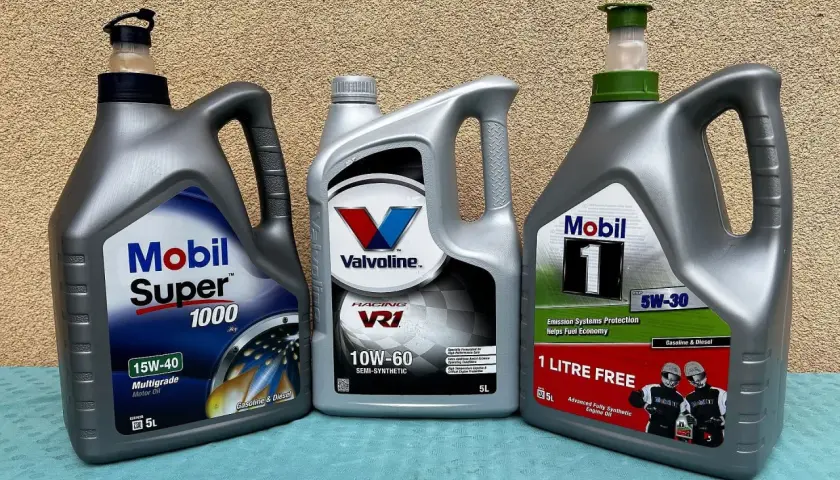 Trzy bańki z olejem silnikowym: Mobil Super 1000, Valvoline VR1 (półsyntetyczny) i Mobil 1 (syntetyczny).