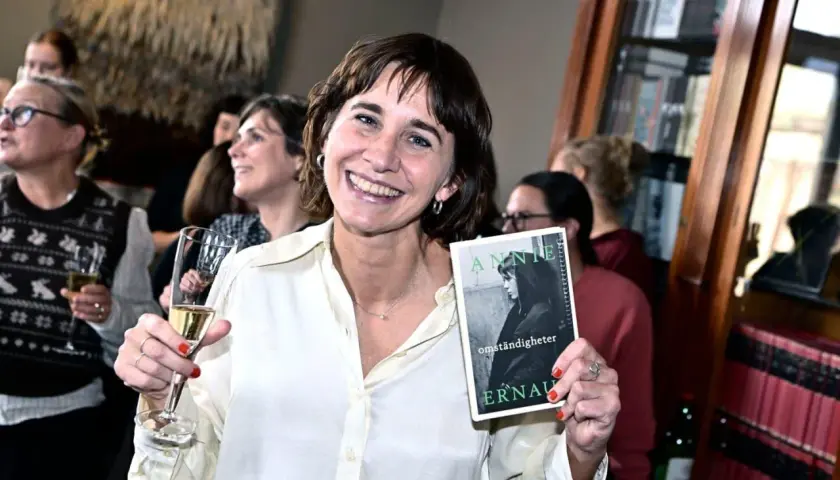 Lisa Lindberg håller upp boken "Annie Ernaux: Omständigheter" vid ett Norstedts-event.