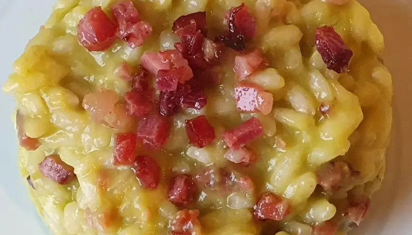 Un cremoso risotto con asparagi e pancetta croccante, un piatto ricco di sapore e profumo.