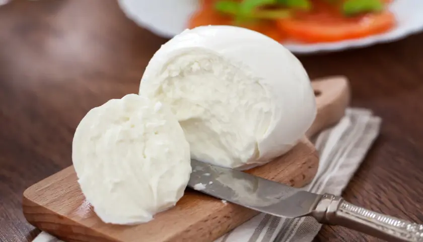 Świeża mozzarella na desce, gotowa do sałatki. Zastanawiasz się, ile tłuszczu ma mozzarella?