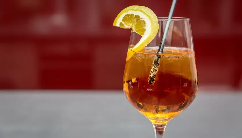 Ein erfrischender Aperitif mit Prosecco, garniert mit einer Zitronenspalte. Perfekt für einen entspannten Moment.