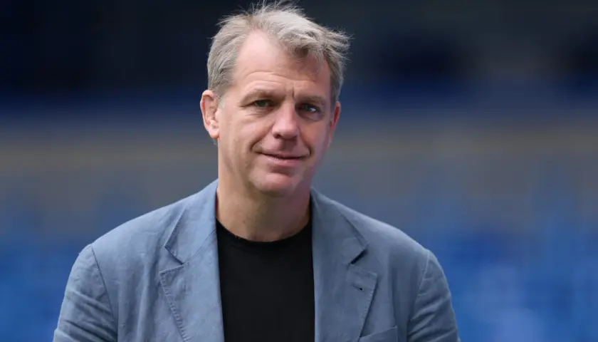 Todd Boehly, właściciel Chelsea, w niebieskiej marynarce na tle stadionu.