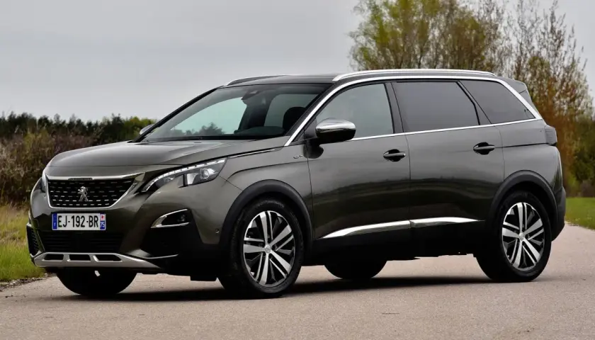 Szary Peugeot 5008 na drodze, widoczne felgi i opony. Rozmiar opon jest kluczowy dla komfortu jazdy tym SUV-em.