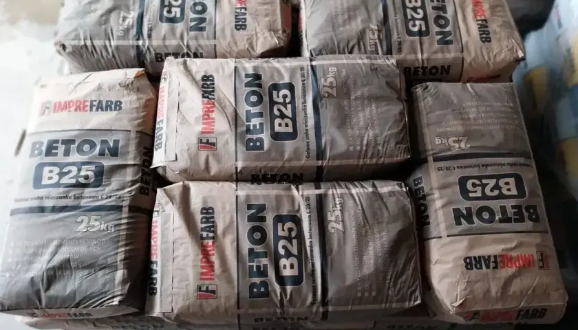 Sześć worków betonu B25, każdy po 25 kg, gotowych do użycia.