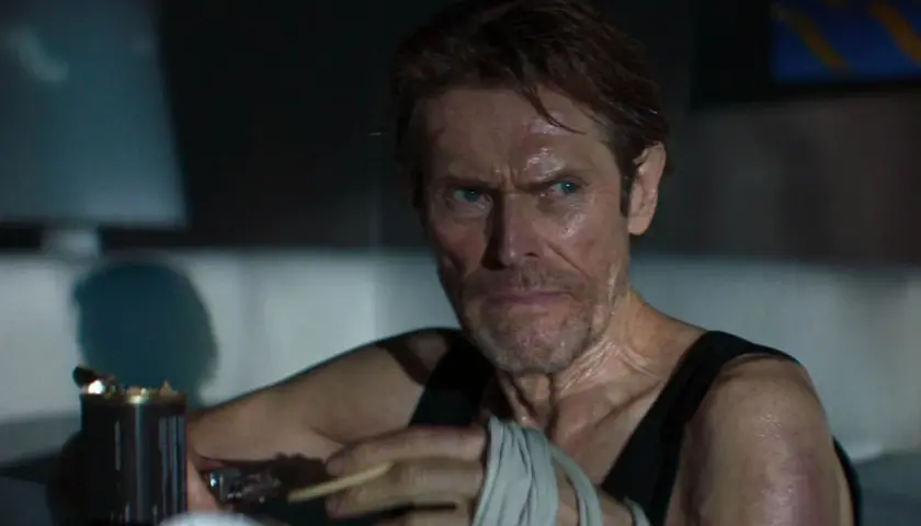Willem Dafoe z papierosem w dłoni, z bandażami na ręce, w scenie sugerującej dobry thriller psychologiczny film.