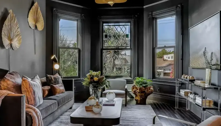Elegancki salon w stylu wiktoriańskim. Ciemne ściany, ozdobne okna i stylowe meble tworzą przytulną atmosferę.