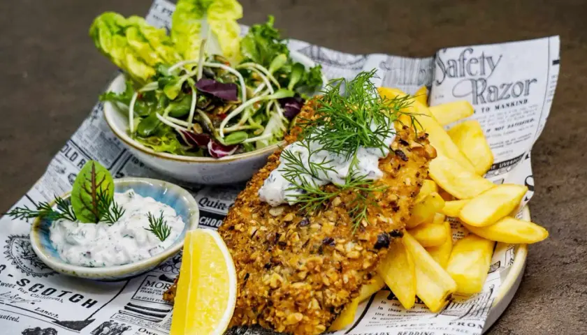 Ryba w panierce z orzechów, frytki, sałatka i sos – idealne danie, które mogłoby znaleźć się w rankingu 10 najlepszych restauracji w Kielcach.