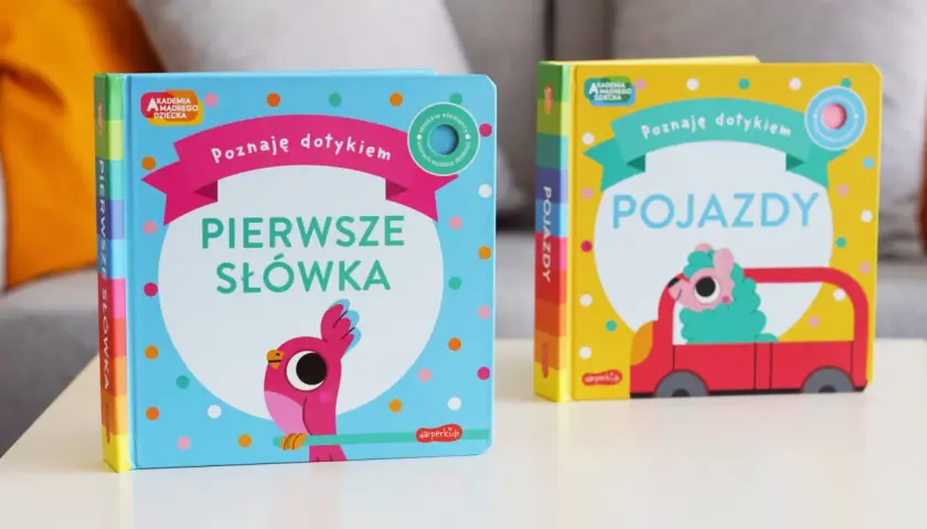 Dwie książeczki z serii Akademia Mądrego Dziecka: "Pierwsze słówka" z ptaszkiem i "Pojazdy" z uroczym stworkiem w czerwonym aucie.