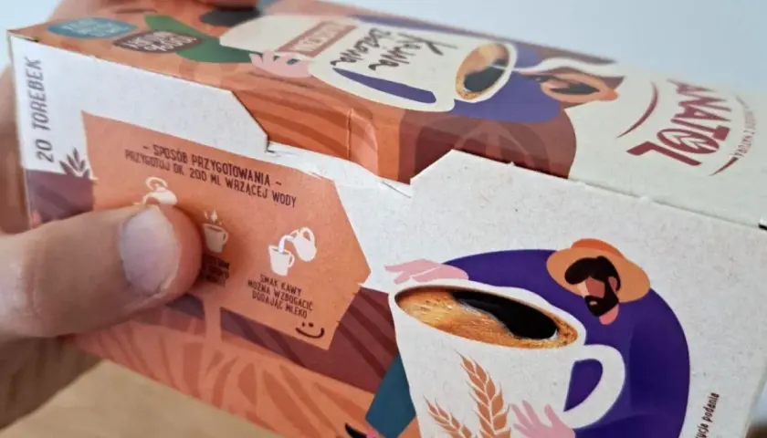 Opakowanie kawy zbożowej Anatol. Na boku instrukcja przygotowania i ilustracja rolnika z kubkiem kawy i kłosami zbóż.