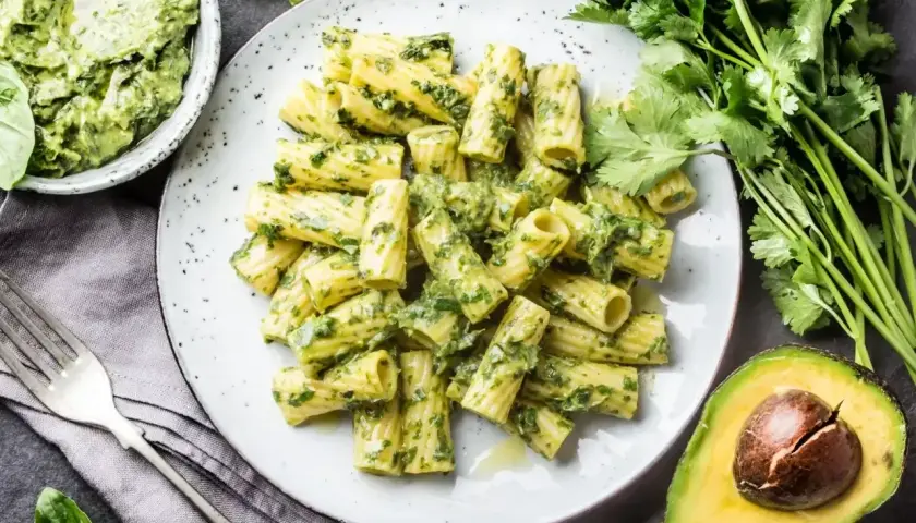 Makaron rigatoni z kremowym pesto zielonym, świeżą kolendrą i awokado. Pyszne danie z aromatycznym pesto zielonym.